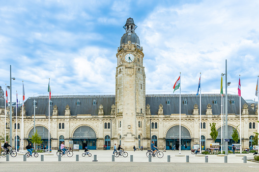 Family bicycling in front of Gare de La Rochelle, the main railway station in La Rochelle, France