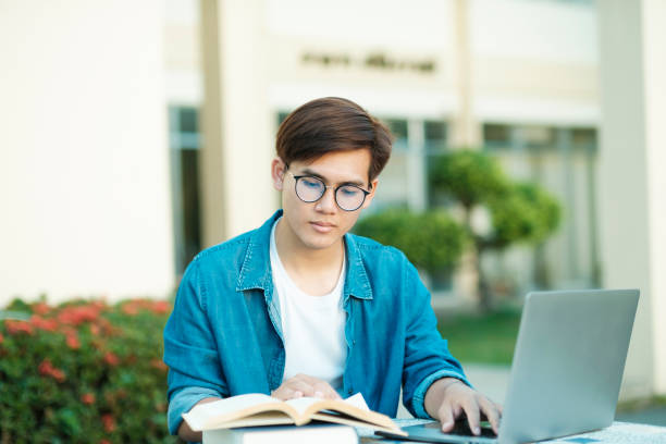 student studying outdoor using laptop. - using laptop contemplation accessibility contemporary imagens e fotografias de stock