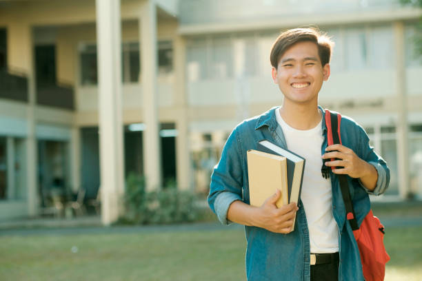 istock Student standing outdoor and holding books. 1488542129