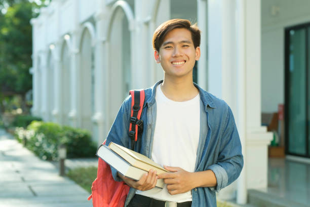 istock Student standing outdoor and holding books. 1488542130
