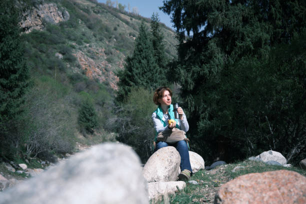 istock Female mountain hiker is resting on the stone 1488549010