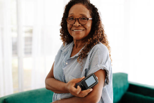 Woman checking her blood sugar levels with continuous glucose monitoring stock photo