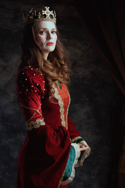 istock medieval queen in red dress with white makeup and crown 1488553024