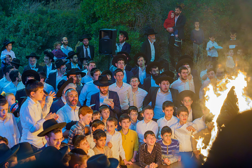 Haifa, Israel - May 08, 2023: Ultra-Orthodox Jews gather around a fire to celebrate the Annual Holiday of Lag-BaOmer, in Haifa, Israel