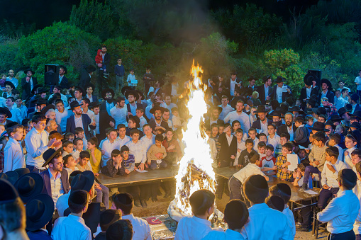 Haifa, Israel - May 08, 2023: Ultra-Orthodox Jews gather around a fire to celebrate the Annual Holiday of Lag-BaOmer, in Haifa, Israel