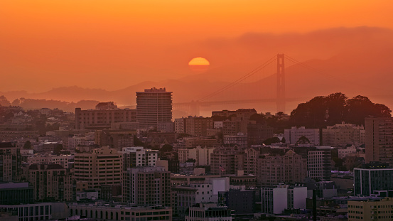 Aerial view of financial buildings against orange sky during sunset, San Francisco California, USA.