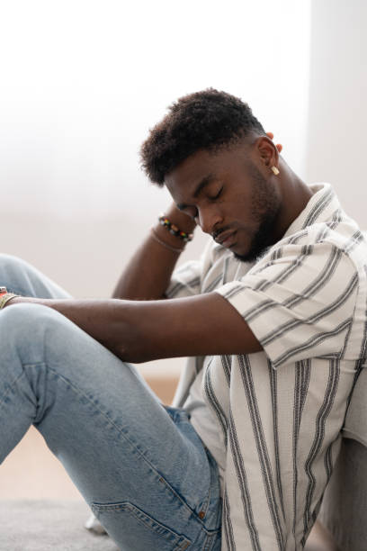 istock Sad black man sitting on the floor. 1488555948