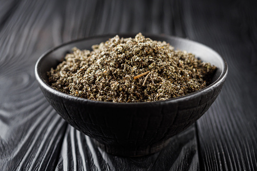 aromatic green dried sage on a black wooden rustic background.