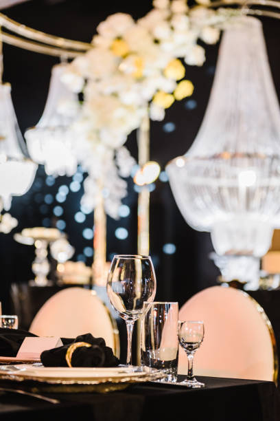 istock Serving, setting table. Plate and glass, stack, wineglass, luxury golden rich decor. Side view. Closeup. Wedding set up, dinner table reception. Birthday, baptism, event. Closeup details interior. 1488557479