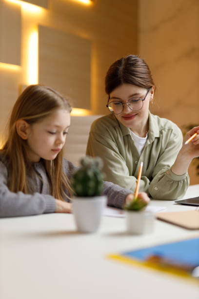 istock Lesson from a private teacher, a little girl writes an assignment. 1488559052