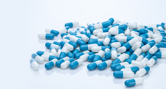 Pila de píldoras de cápsulas azules y blancas. Producto farmacéutico. Medicamentos recetados. Salud y medicina. Industria farmacéutica. Ciencia farmacéutica. Medicamentos recetados. Producción de píldoras en cápsulas. photo