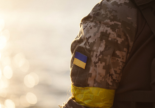 la bandera ucraniana en forma de chevron en la mano de un militar photo