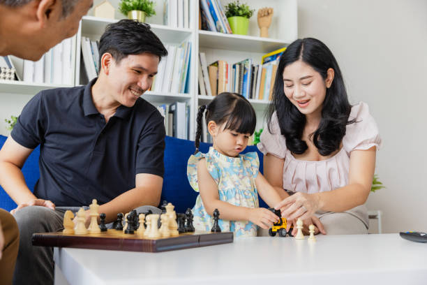 istock Multigenerational playing chess together in living room, daughter. 1488560644