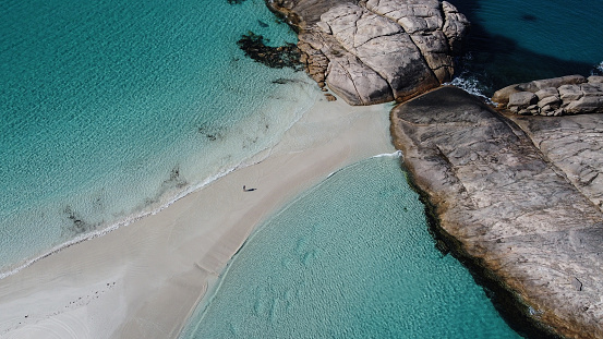Person walking in the sand between two beaches in Wylie Bay, Western Australia. Aerial picture of Esperance amazing blue water in Australia. Very beautiful and calm landscape. Drone shot.