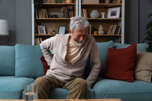istock Aged grey haired senior red face man writhes in pain suffers from low back strain, touch rubbing or massaging loin reduces backache. Degenerative disk disease, pinched nerve rheumatism concept 1488563434