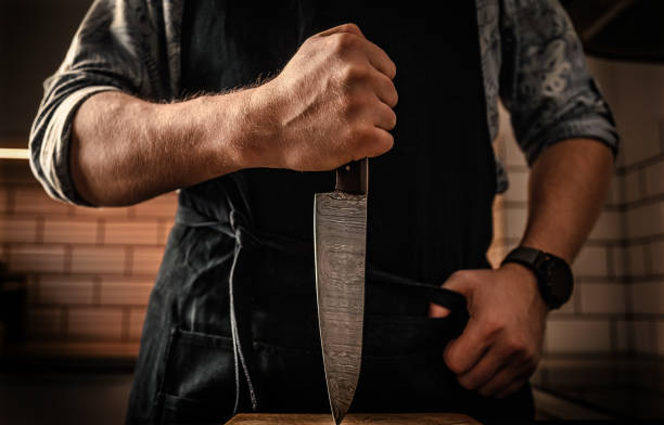 istock Chief man in apron holding knife at kitchen 1488564700