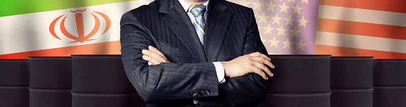 Smiling businessman smiling and looking at camera in a head and shoulders portrait against white wall. Space around him allows room for text.