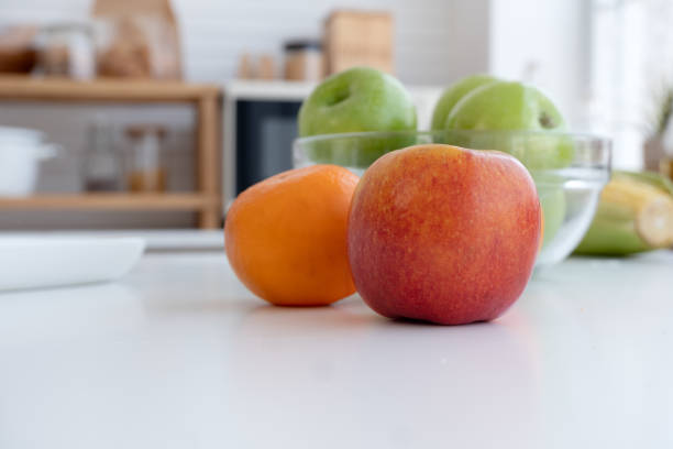 istock Red apple and green apple on the white table in the kitchen. 1488566445