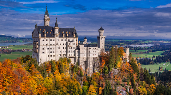 09/24/2020 Schwangau, Bavaria, Germany.\nHigh angle view of Neuschwanstein castle in Autumn, forest surrounding it.