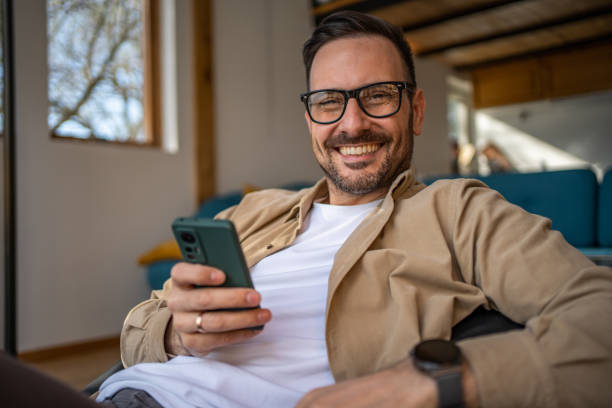 istock A middle-aged man in his cottage is lying on a large comfortable sack, which is placed next to a large window with a beautiful view of the nature outside. 1488566801