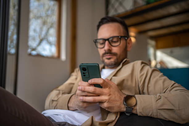 istock A middle-aged man in his cottage is lying on a large comfortable sack, which is placed next to a large window with a beautiful view of the nature outside. 1488566822