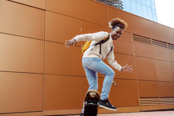 jeune homme faisant des cascades de patinage - hip hop hipster afro men photos et images de collection