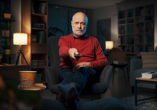 istock Relaxed senior man watching TV at home 1488569253