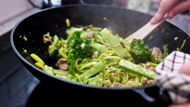 Meat with fresh vegetables cooking in asian wok pan