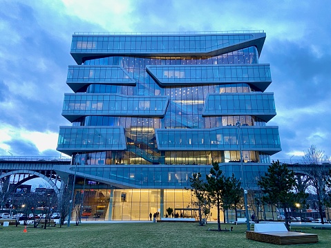 New York, NY USA - January 20, 2023 : The glass facade of Columbia Business School's Henry Kravis Hall designed by Diller Scofidio + Renfro lit up at dusk in Manhattanville, New York City