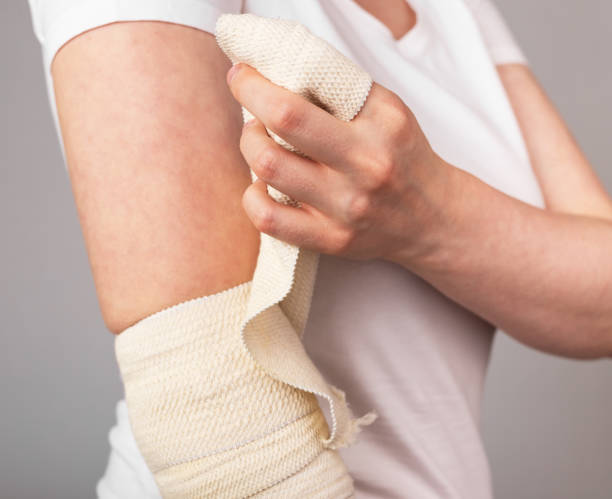 istock Woman wrapping elastic bandage around painful elbow. Compression wrap. Arm injury, overuse, inflammation, arthritis consequences. Health care concept. 1488573373