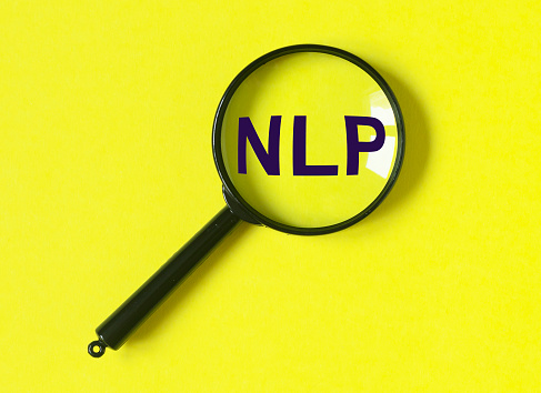 Neuro-linguistic programming, NLP acronym through magnifying glass. High quality photo
