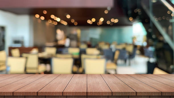 istock Empty wooden table top with lights bokeh on blur restaurant background. 1488573683