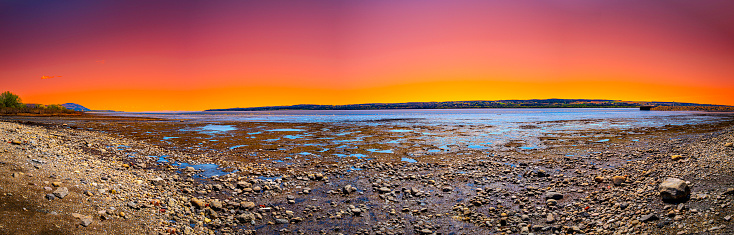 Quebec twilight dramatic sunset landscape over the St. Lawrence River at low tide, with the view of the Ile D'Orleans from Cote de Beaupre near Quebec City, Canada, the view from the Peace Wharf