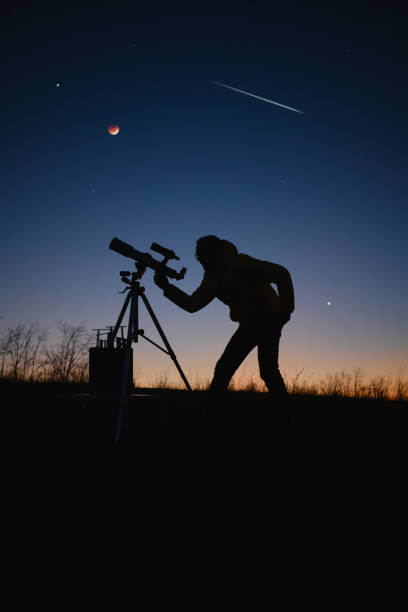 istock Astronomer looking at the starry skies, planets, meteor shower and lunar eclipse with a telescope. 1488577569
