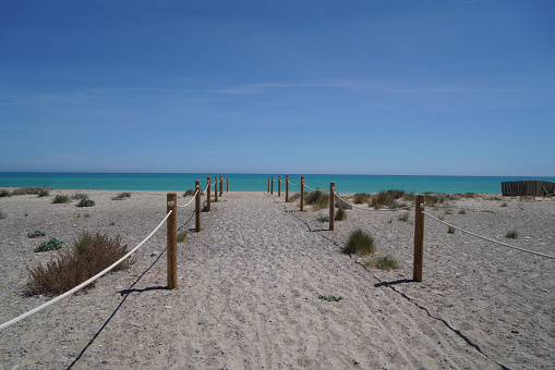 Path to the Mediterranean beach with sunshine and blue sky