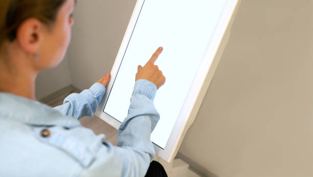 istock Woman using digital touch screen for the self check-in. 1488579537