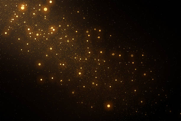 Gold sparkles and glitter on black background.