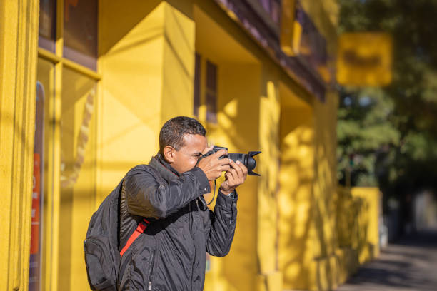 istock Latino photographer taking a picture with his camera with copy space. 1488579899