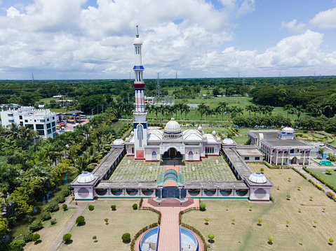 Barisal, Bangladesh – August 08, 2022: Aerial view of Baitul Aman Mosque. Drone view of Guthia Mosque in Barisal City Landmark. Baitul Aman Jame Masjid Complex, commonly known as Guthia Mosque of Barisal, is a mosque complex of Bangladesh.  The Baitul Aman Jame Masjid Complex consists of a mosque, a large eidgah, a graveyard, three lakes, a madrasa and an orphanage. Established on December 16, 2003, Guthia Mosque is also a tourist spot in Bangladesh.