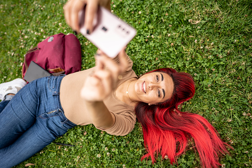 Young student taking a selfie on the public park