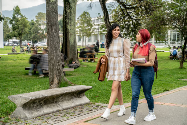 istock Female student friends are talking while walking through the public park 1488581477