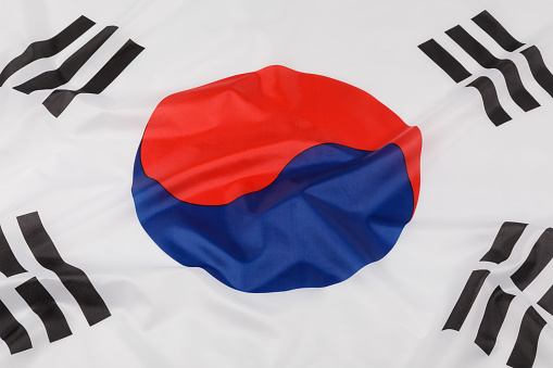 Small paper flag of South Korea pinned. Isolated on white background. Horizontal orientation. Close up photography. Copy space.