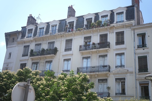 An old multi-story building balconies with potted plants. France.
