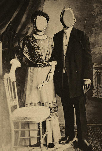 Classic portrait photo of a young couple. The faces have been cut out. The memory and history is irretrievably destroyed.