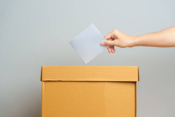 voting and democracy concept. man hand putting ballot in election box, democracy referendum for government, president and prime minister vote - vote casting imagens e fotografias de stock