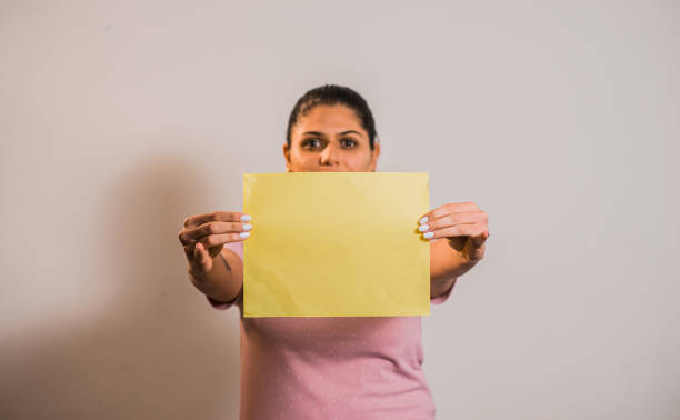 istock College student with colored papers on gray background, Young woman playing and interacting with colored papers. 1488591826