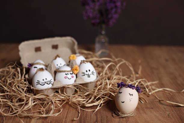 istock Smiley face drawn,decorated easter eggs in egg carton on straw on brown background 1488595643