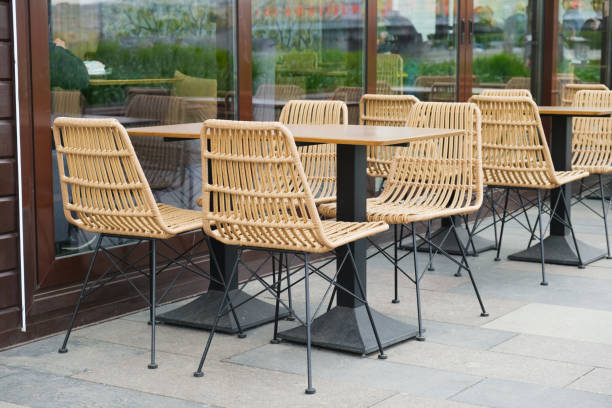 empty tables and plastic wicker chairs on the summer terrace near a small cafe - fake rattan imagens e fotografias de stock