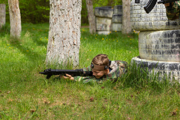istock Boy weared in camouflage playing laser tag in special forest playground. 1488597932