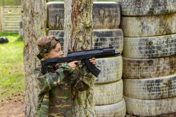 istock Boy weared in camouflage playing laser tag in special forest playground. 1488598247